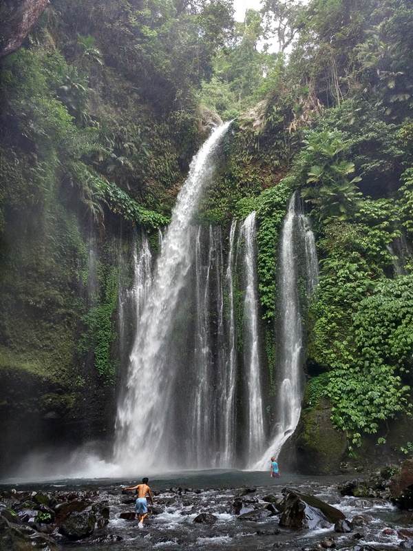 Personas bañándose en la cascada de Tiu Kelep